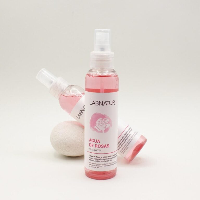 Tres envases de Agua de Rosas 125ml Labnatur colocados en distintas posiciones junto a una piedra blanca