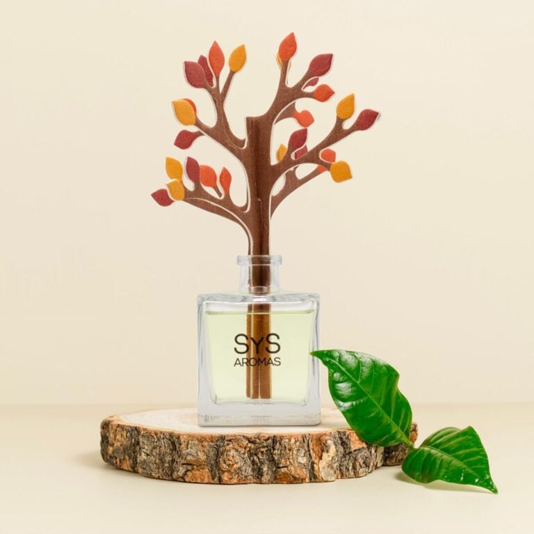 Ambientador Difusor Árbol Aloe Vera-Bambú 90ml SYS Aromas sobre rodaja de madera con hojas verdes