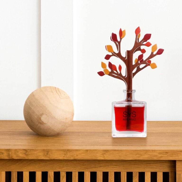 Ambientador Difusor Árbol Frutos Rojos 90ml SYS Aromas sobre mueble de madera junto a esfera decorativa