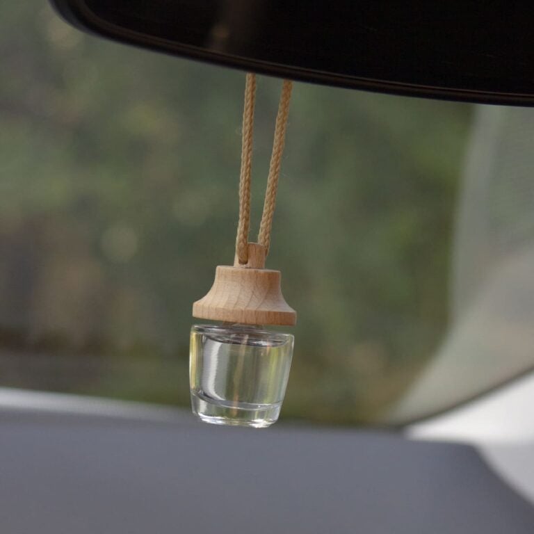 Ambientador Coche Rosas 7ml SYS Aromas colgado del retrovisor interior de un vehículo