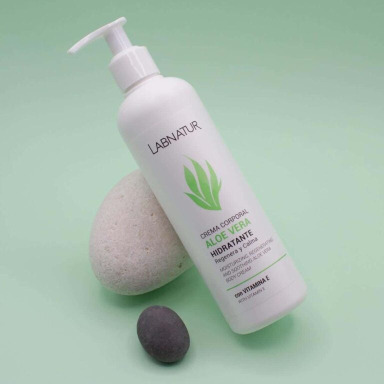 Envase inclinado de Crema Corporal Aloe Vera 400ml Labnatur junto a una piedra clara y otra oscura