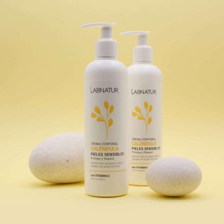 Dos envases de Crema Corporal Caléndula 300ml Labnatur entre dos piedras claras sobre fondo amarillo
