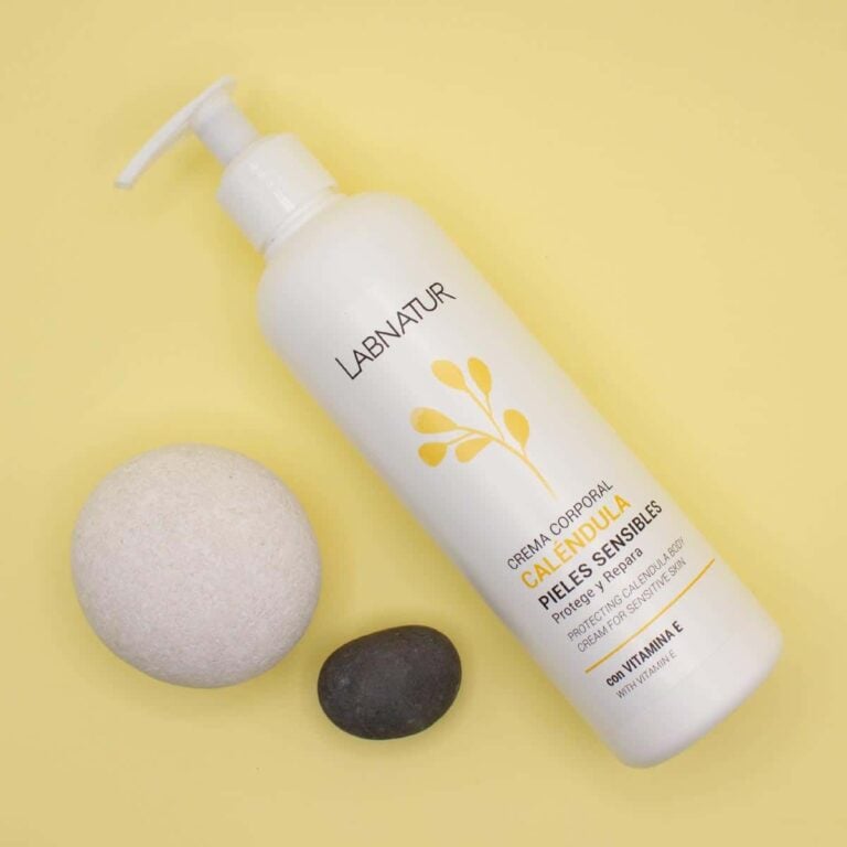 Envase inclinado de Crema Corporal Caléndula 300ml Labnatur junto a una piedra clara y otra oscura