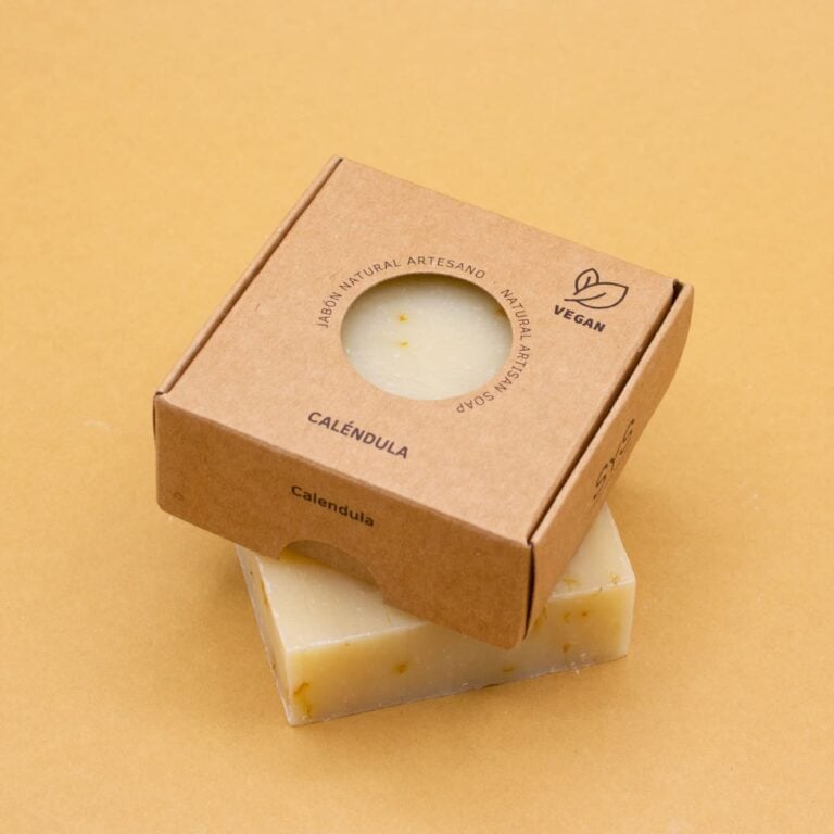 Jabón Natural Artesano Caléndula 100g Labnatur en tono crema con pétalos visibles delante de su estuche kraft vegano
