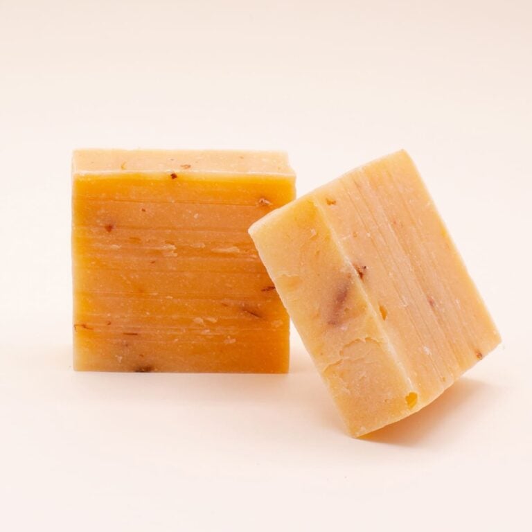 Dos pastillas naranjas de Jabón Natural Artesano Naranja y Azahar 100g Labnatur sobre fondo beige claro