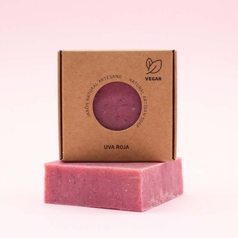 Estuche kraft de Jabón Natural Artesano Uva Roja 100g Labnatur apoyado sobre una pastilla rosa