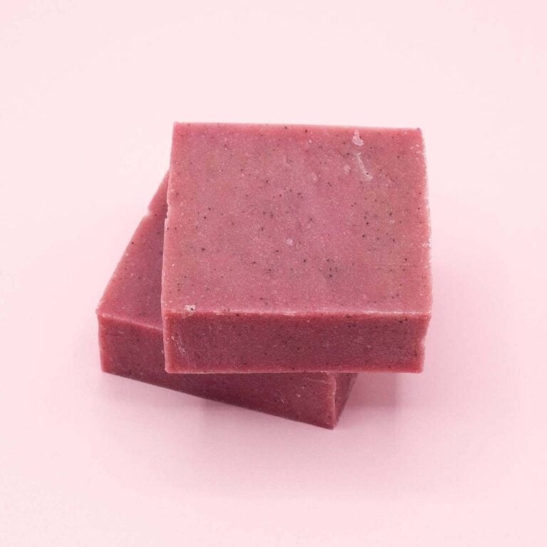 Dos pastillas rosas de Jabón Natural Artesano Uva Roja 100g Labnatur superpuestas sobre fondo rosa claro