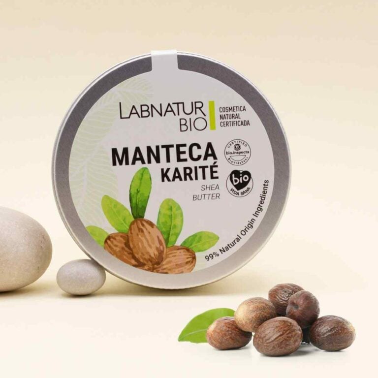 Manteca Corporal de Karité 230ml Labnatur Bio junto a frutos de karité, una hoja verde y piedras claras
