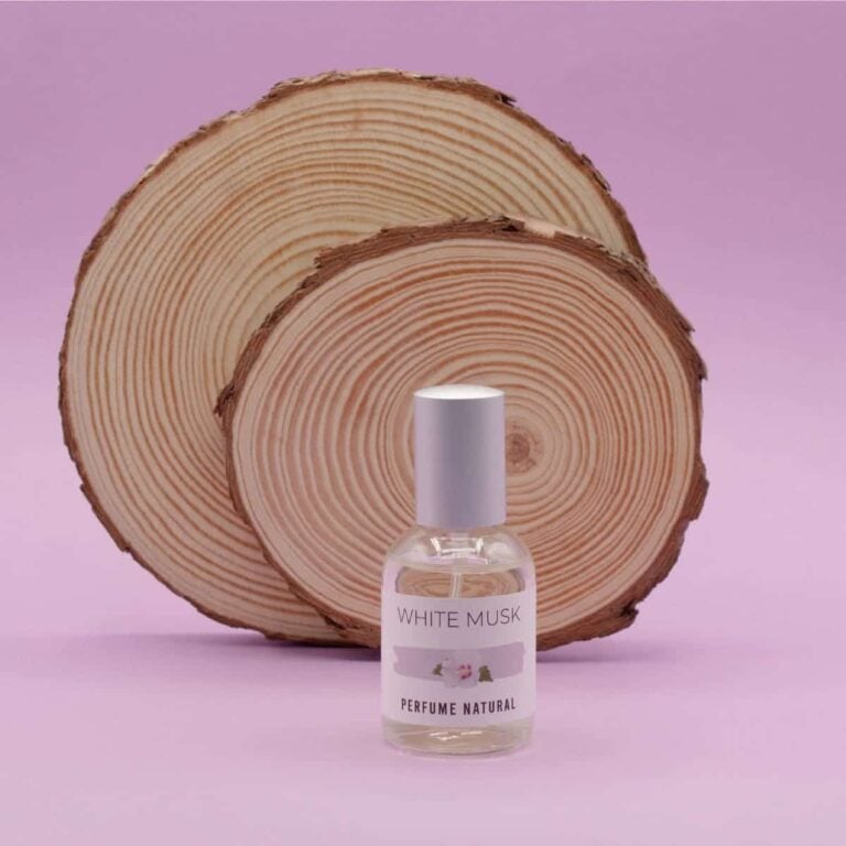 Perfume White Musk 50ml Labnatur delante de dos grandes rodajas de madera sobre fondo rosa