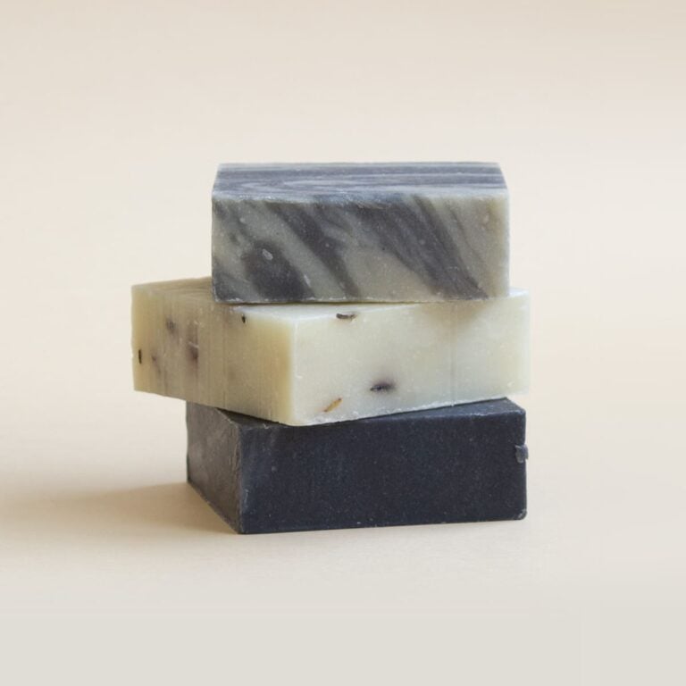 Tres jabones naturales Labnatur en tonos negro, crema y gris marmolado apilados sobre fondo beige