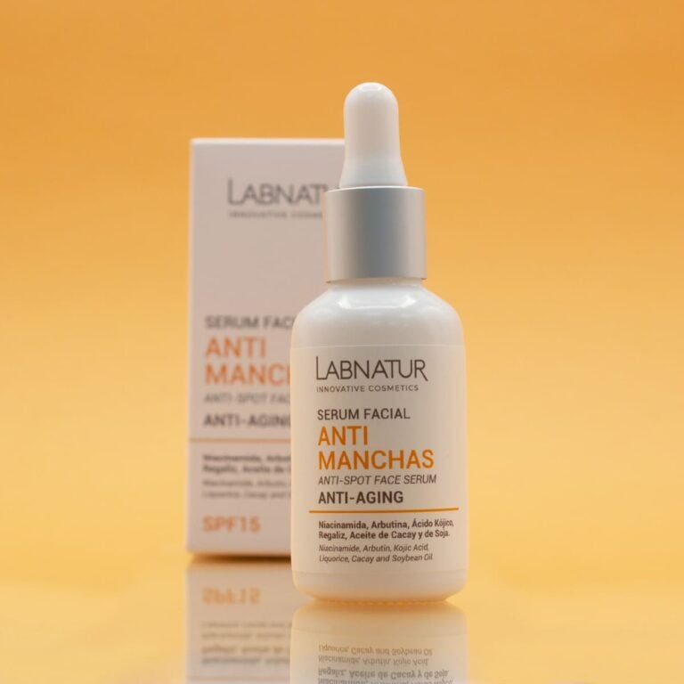 Frasco con pipeta del Sérum Facial Anti Manchas 30ml Labnatur sobre fondo naranja con estuche desenfocado.