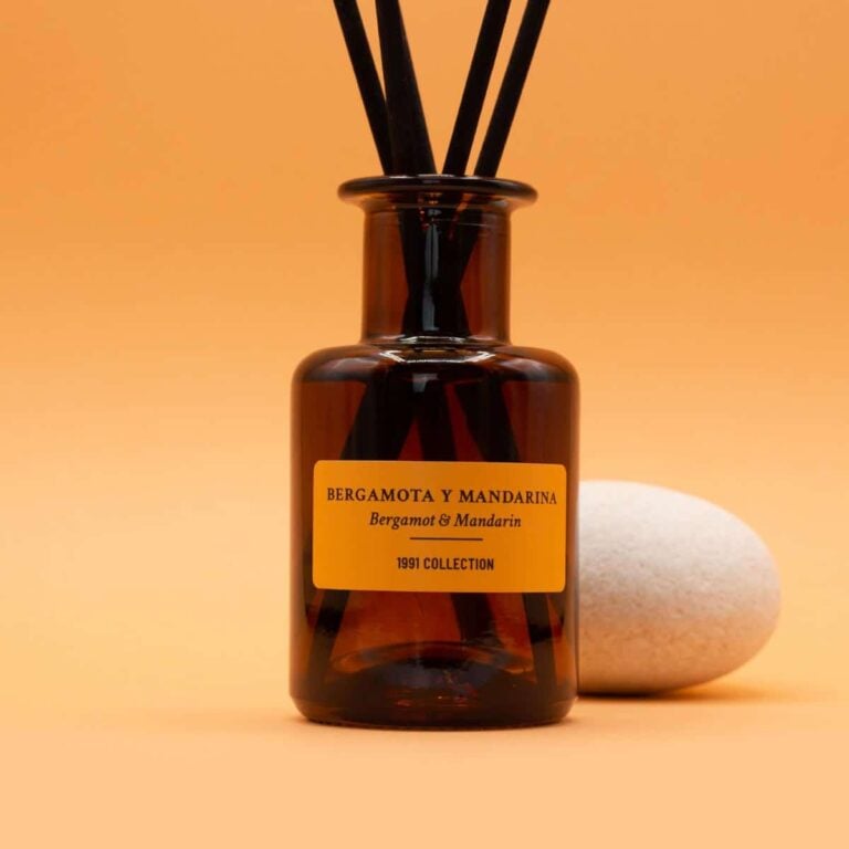 Primer plano del Ambientador Mikado Bergamota y Mandarina 100ml SYS Aromas con varillas negras y piedra blanca