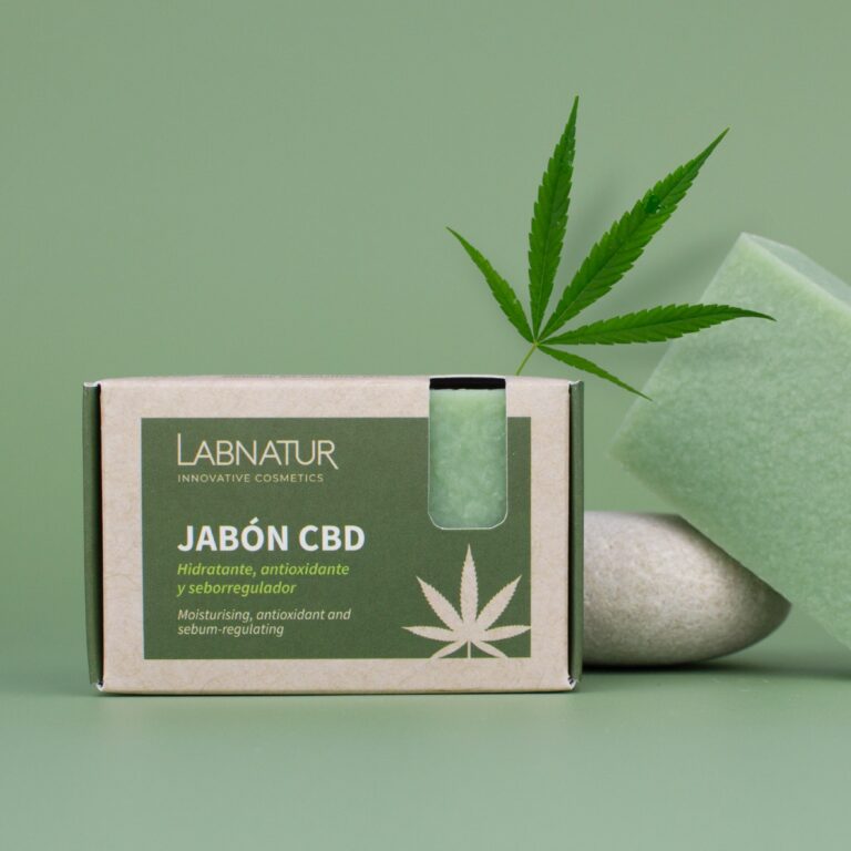 Jabón Natural CBD 100g Labnatur con caja, pastilla verde y hoja de cáñamo sobre fondo verde.