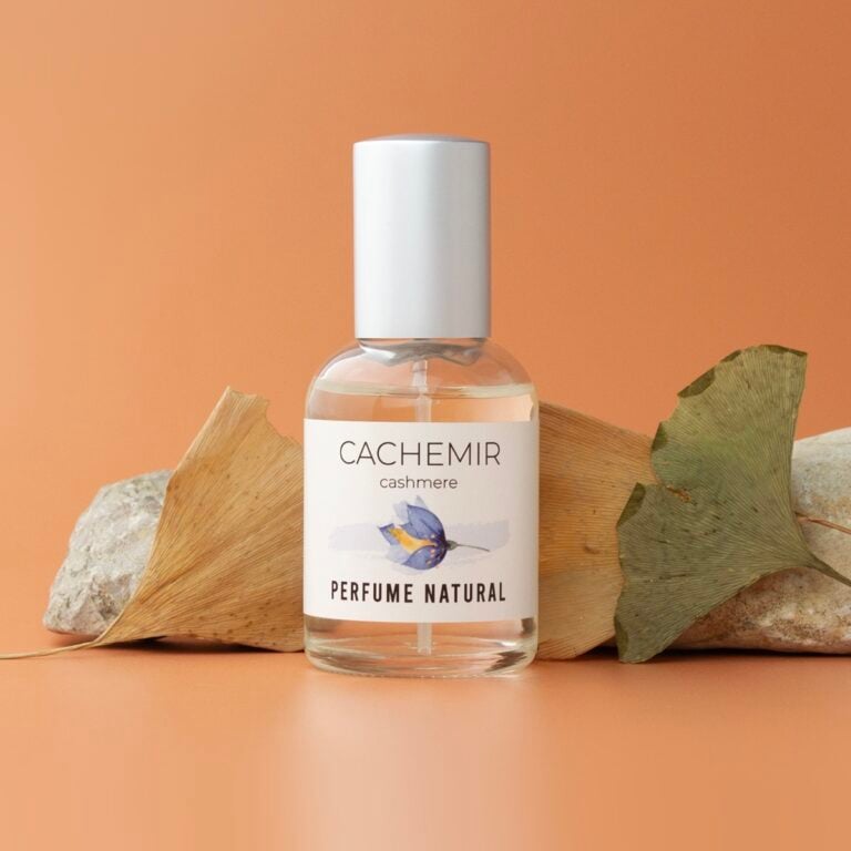 Perfume Cachemir 50ml Labnatur delante de hojas secas y piedras claras sobre fondo naranja